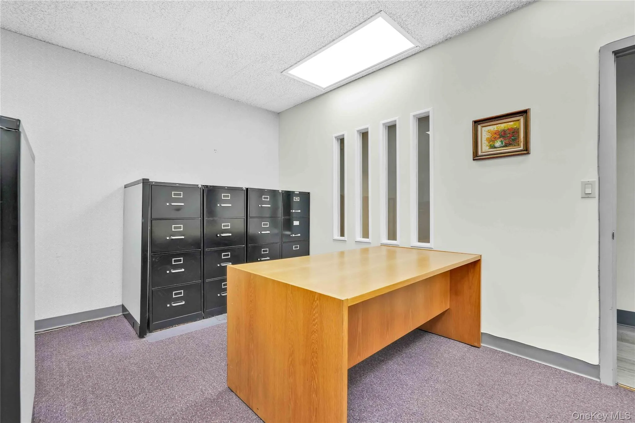 Office space with light carpet and a textured ceiling Office space with light carpet and a textured ceiling