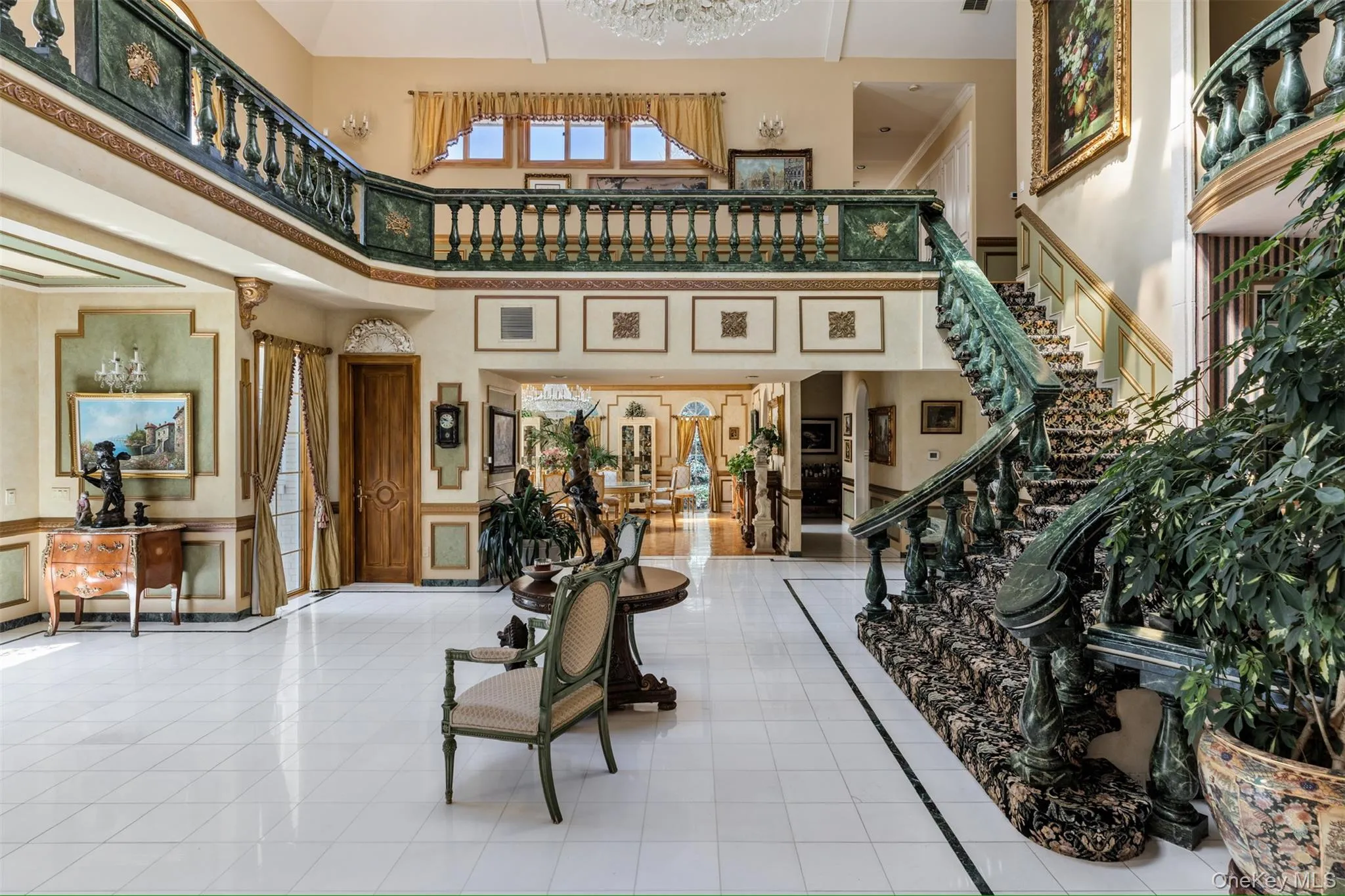 Lobby featuring a towering ceiling, a decorative wall, and stairs Lobby featuring a towering ceiling, a decorative wall, and stairs