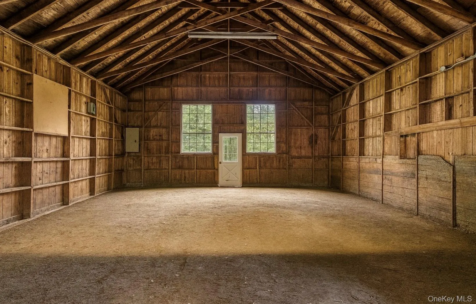 Misc room with high vaulted ceiling and electric panel Misc room with high vaulted ceiling and electric panel