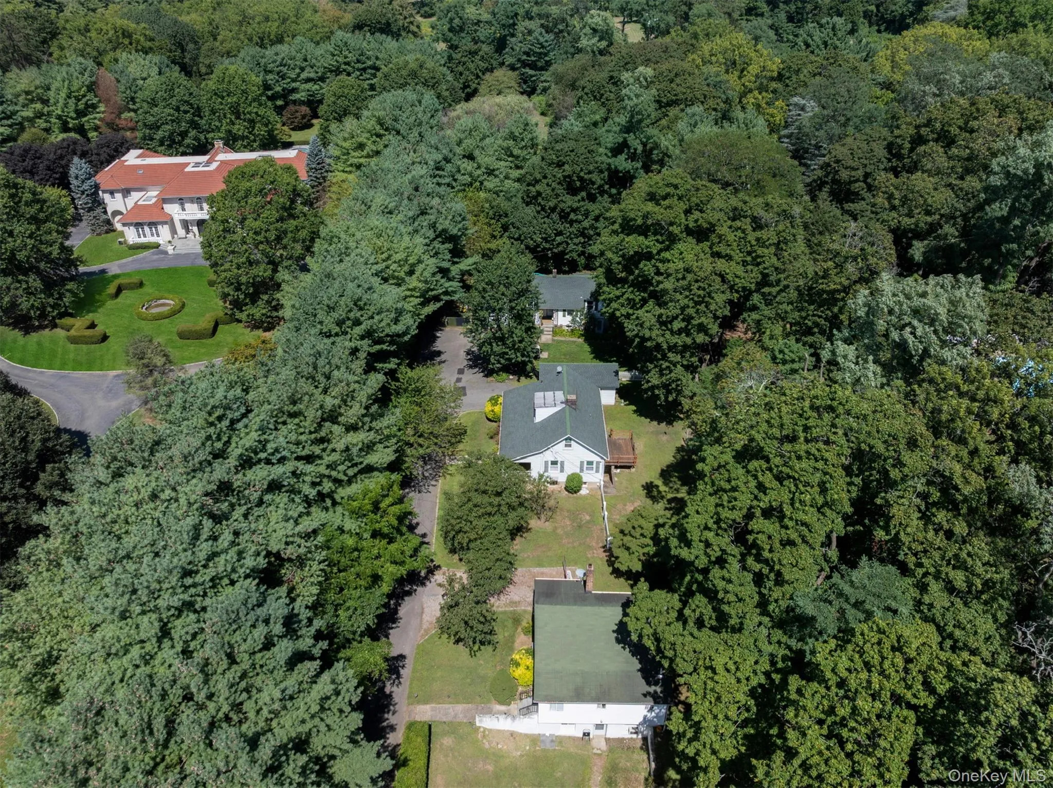 Aerial view of property and surrounding area with a heavily wooded area Aerial view of property and surrounding area with a heavily wooded area