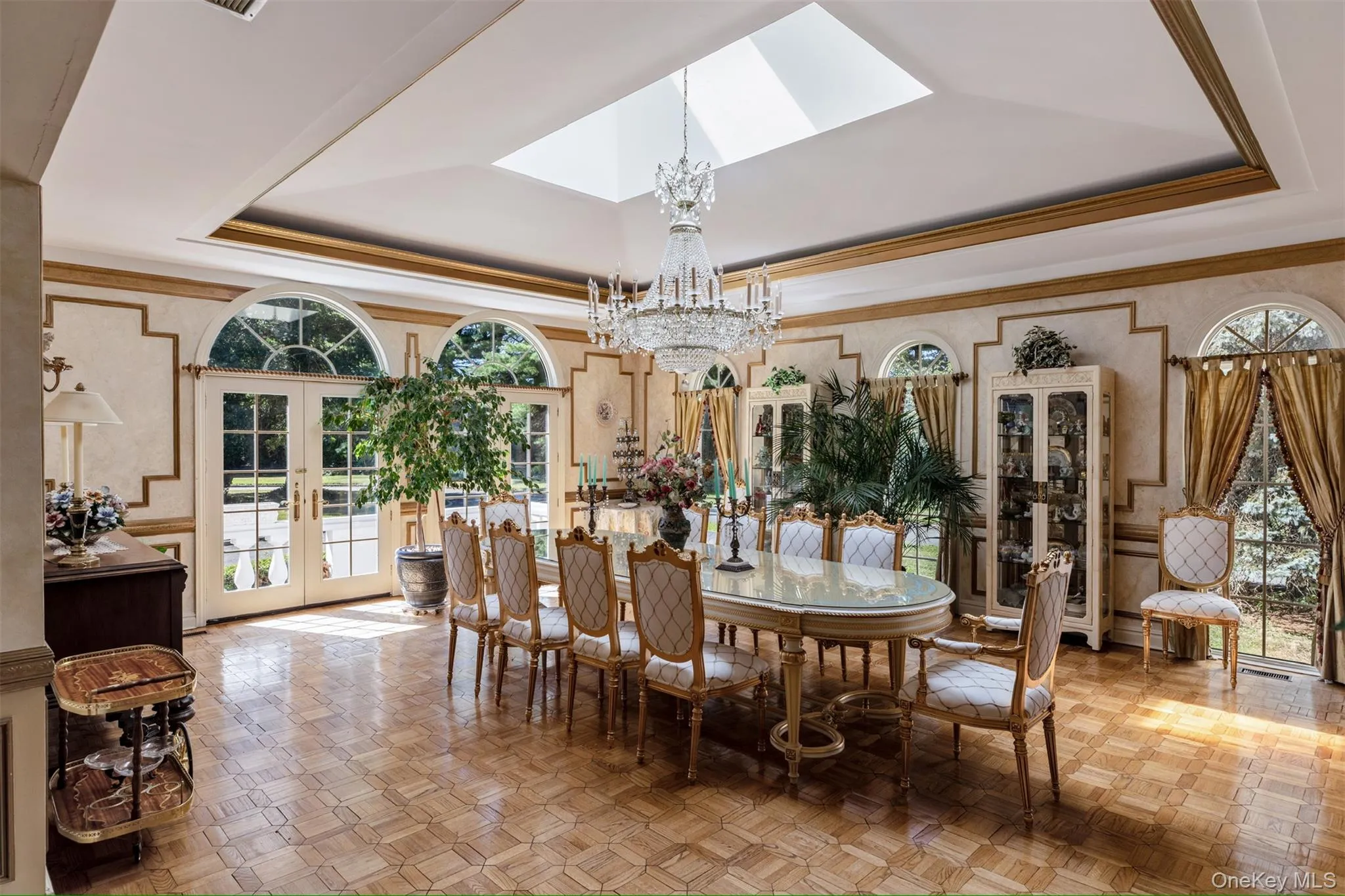 Dining room with a tray ceiling, french doors, healthy amount of natural light, crown molding, and a chandelier Dining room with a tray ceiling, french doors, healthy amount of natural light, crown molding, and a chandelier