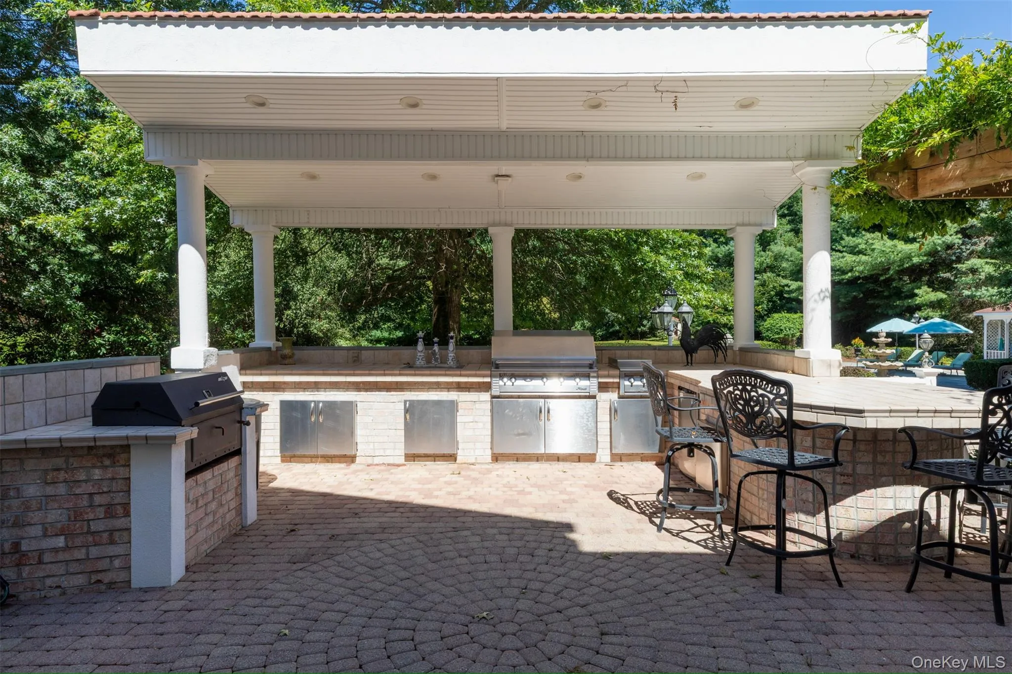 View of patio with exterior bar, view of wooded area, and area for grilling View of patio with exterior bar, view of wooded area, and area for grilling