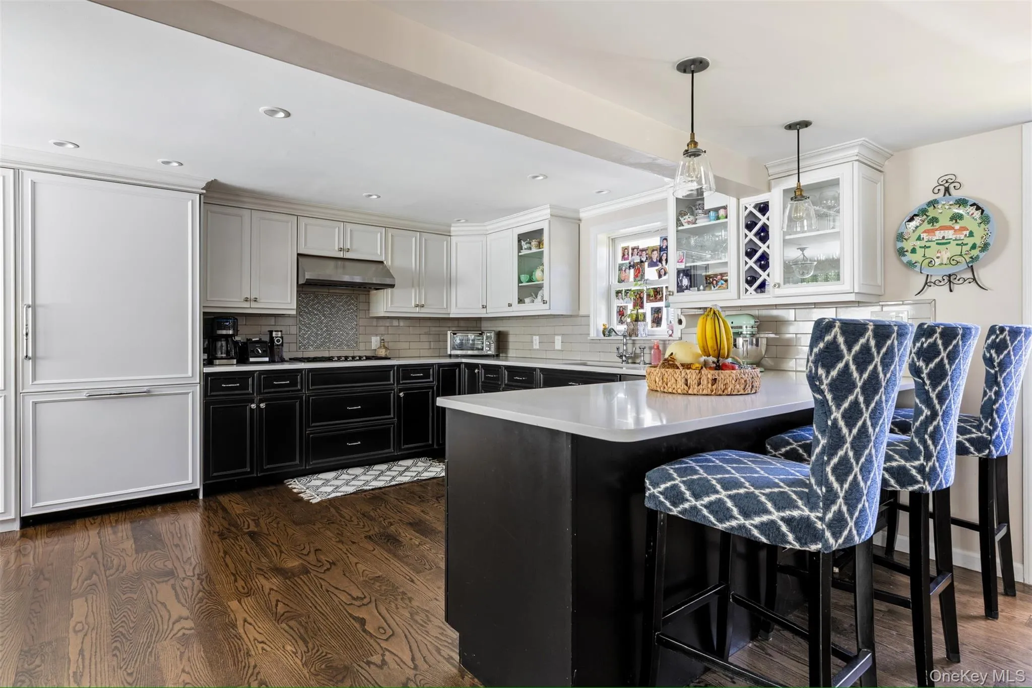 Kitchen featuring dark cabinetry, a breakfast bar area, decorative backsplash, a peninsula, and recessed lighting Kitchen featuring dark cabinetry, a breakfast bar area, decorative backsplash, a peninsula, and recessed lighting