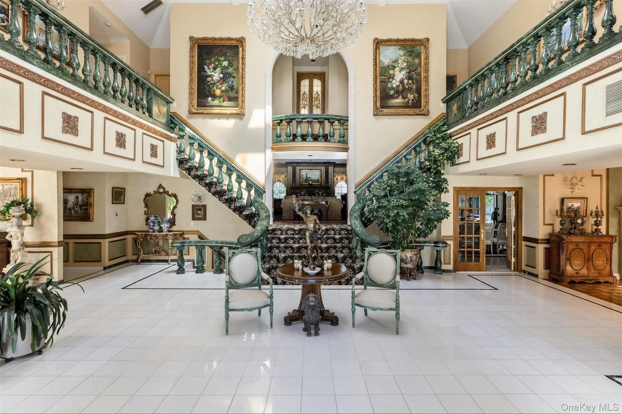 Community lobby with stairway, a wainscoted wall, a decorative wall, and a towering ceiling Community lobby with stairway, a wainscoted wall, a decorative wall, and a towering ceiling