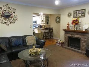 Living area featuring a fireplace and wood finished floors Living area featuring a fireplace and wood finished floors