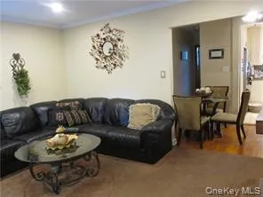 Living area featuring wood finished floors and crown molding Living area featuring wood finished floors and crown molding