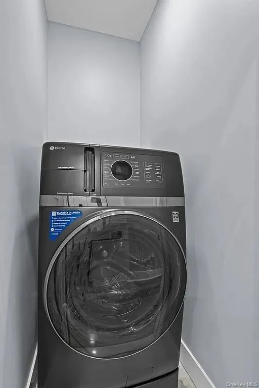 Laundry area featuring washer / clothes dryer and baseboards Laundry area featuring washer / clothes dryer and baseboards