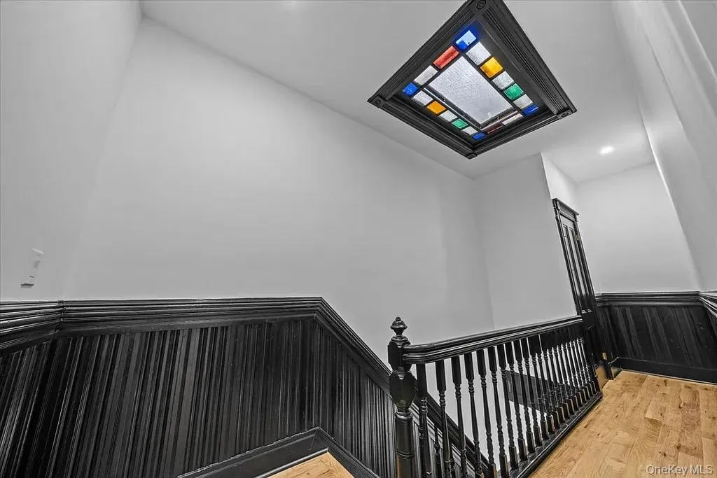 Stairway with a wainscoted wall, wood finished floors, recessed lighting, and wood walls Stairway with a wainscoted wall, wood finished floors, recessed lighting, and wood walls
