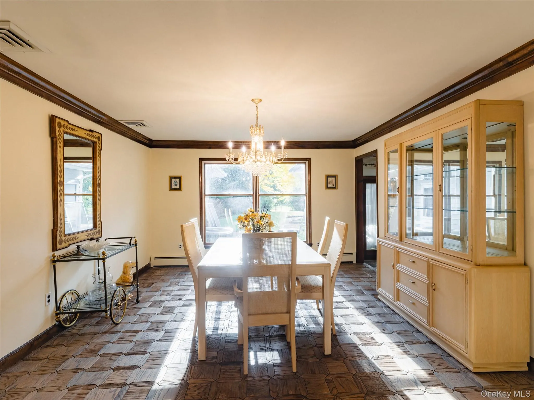Dining space with crown molding, a chandelier, and a baseboard heating unit Dining space with crown molding, a chandelier, and a baseboard heating unit
