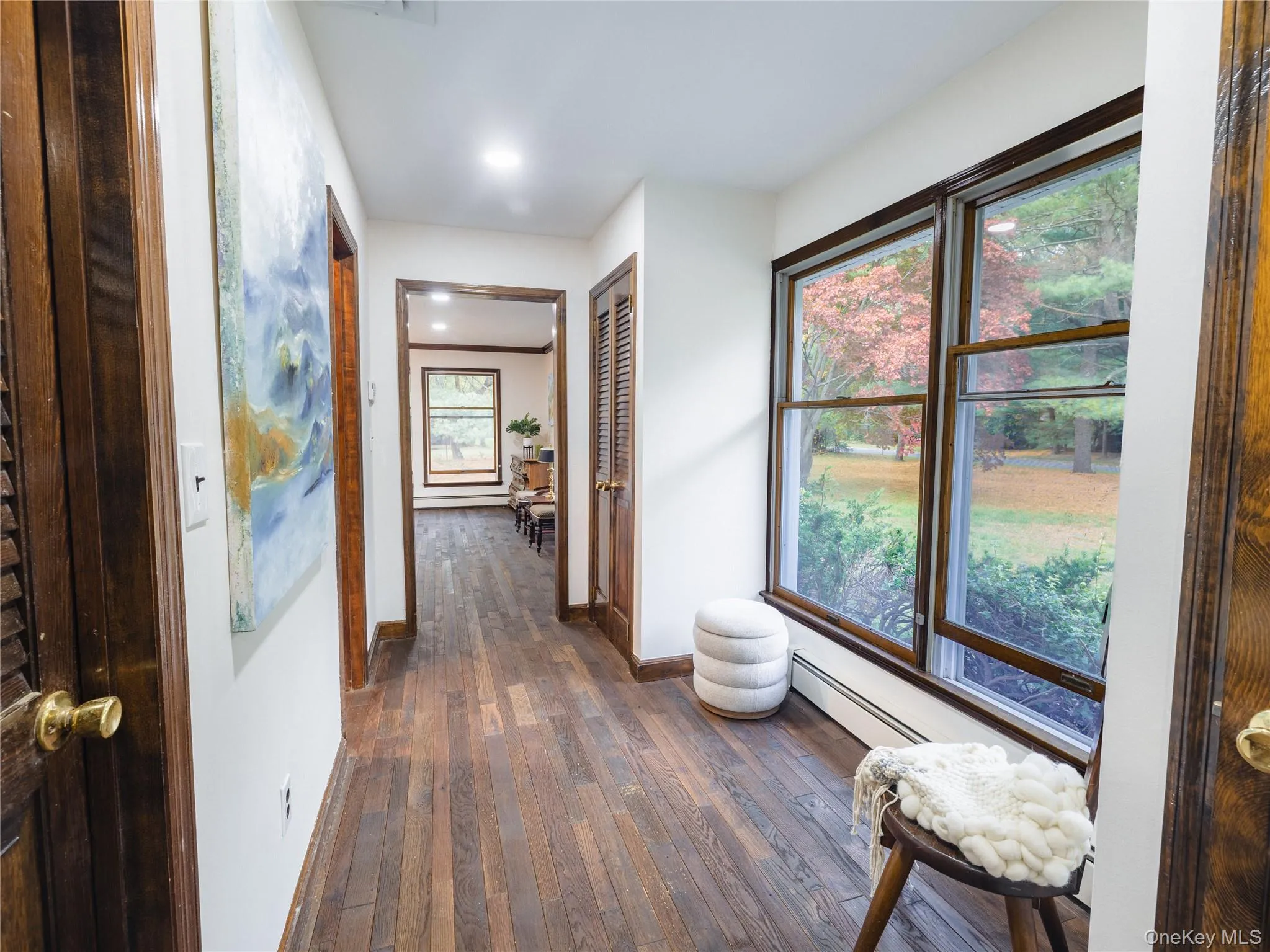 Corridor with dark wood-type flooring, baseboard heating, and recessed lighting Corridor with dark wood-type flooring, baseboard heating, and recessed lighting
