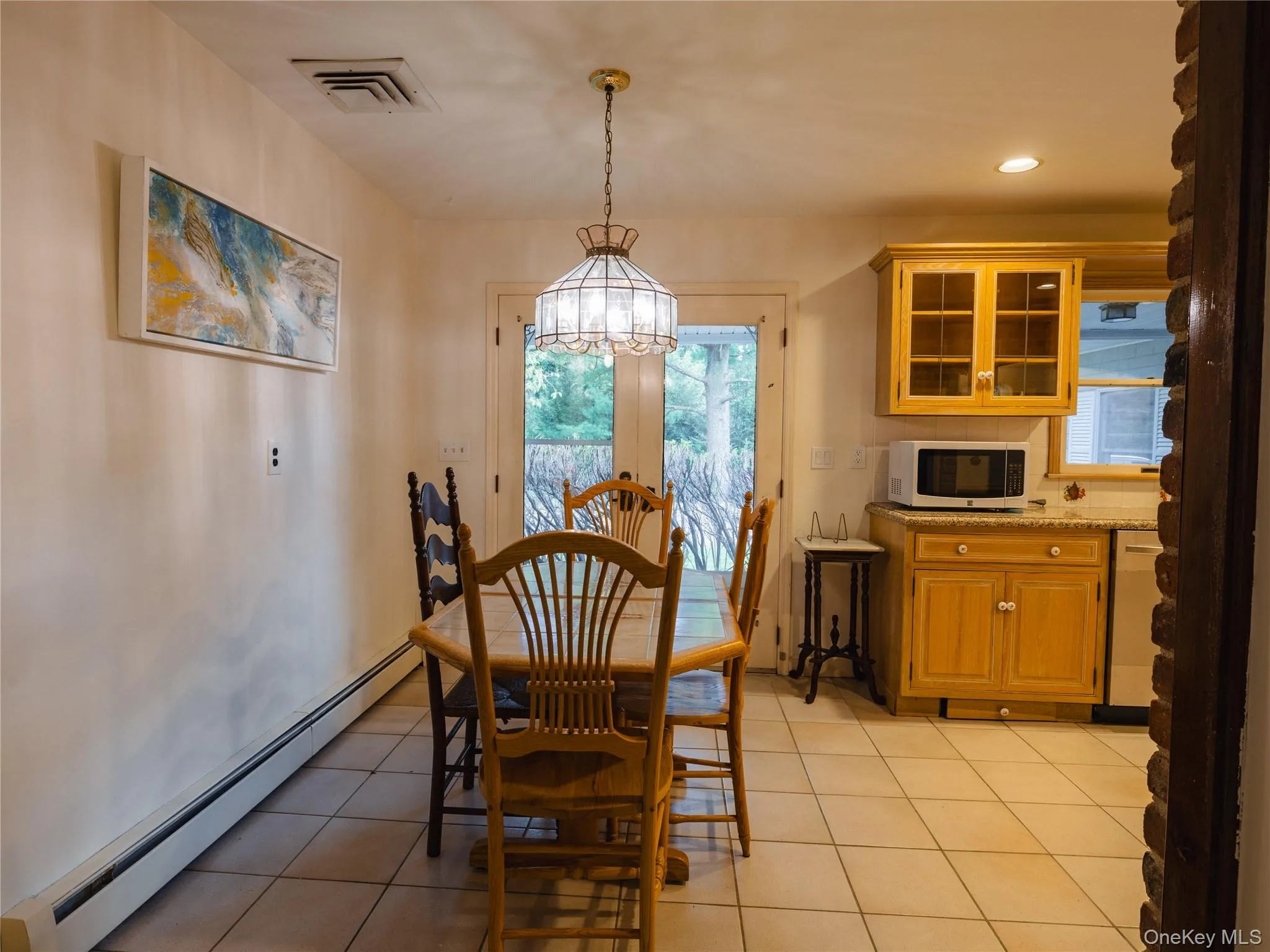 Dining room with a baseboard radiator, light tile patterned floors, recessed lighting, and a chandelier Dining room with a baseboard radiator, light tile patterned floors, recessed lighting, and a chandelier