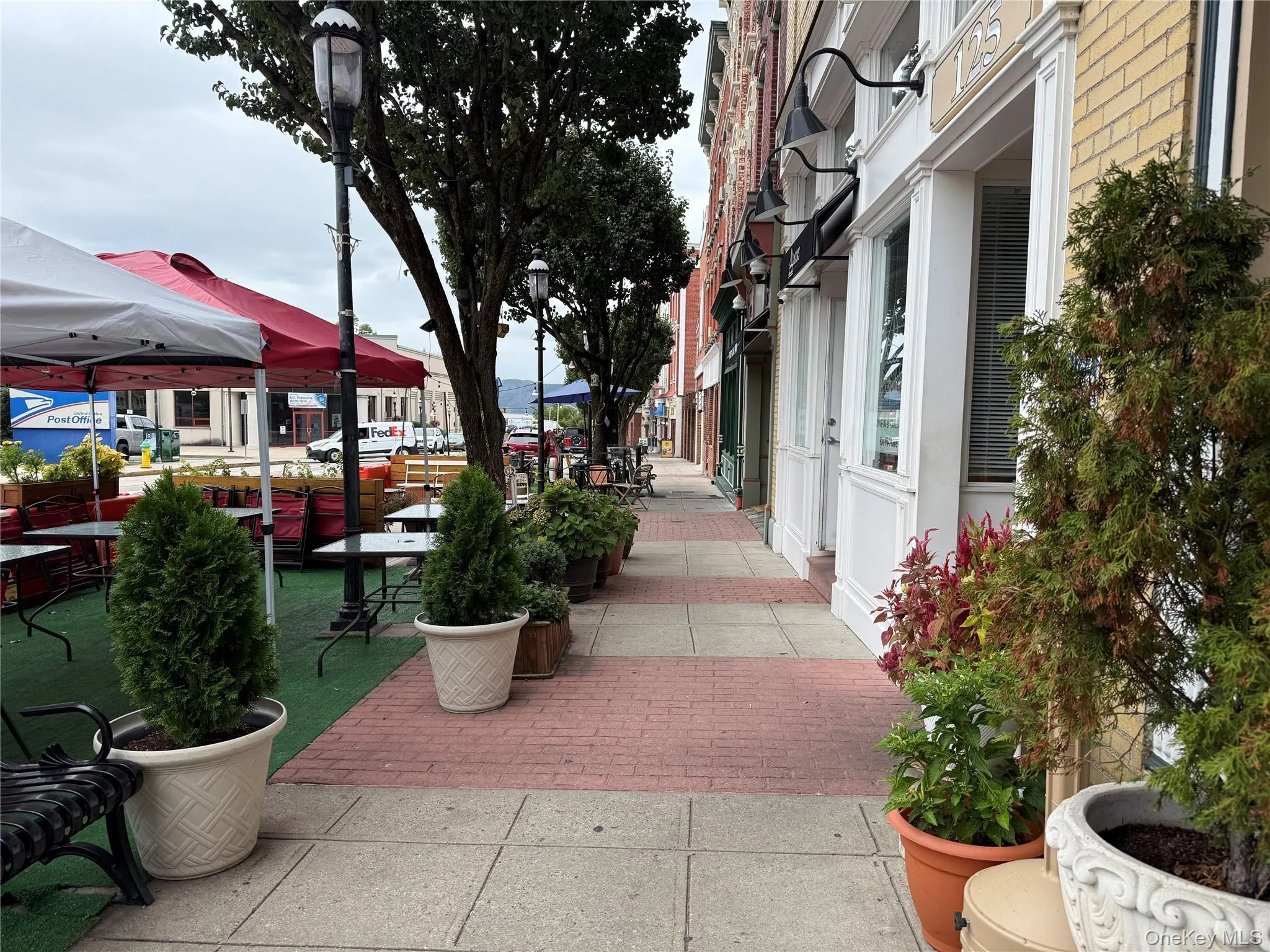 Clean, vibrant sidewalk in front of building, with coffee shop and many cafes Clean, vibrant sidewalk in front of building, with coffee shop and many cafes