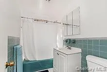 main unit Bathroom tile walls, shower / tub combo, vanity, and wainscoting main unit Bathroom tile walls, shower / tub combo, vanity, and wainscoting
