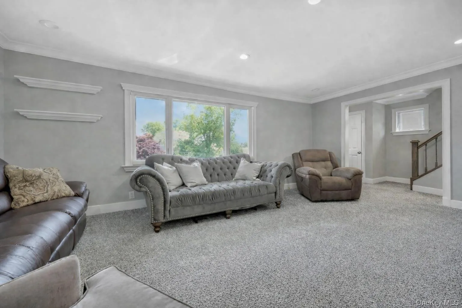Bright and sun filled living room opening to entry hall Bright and sun filled living room opening to entry hall