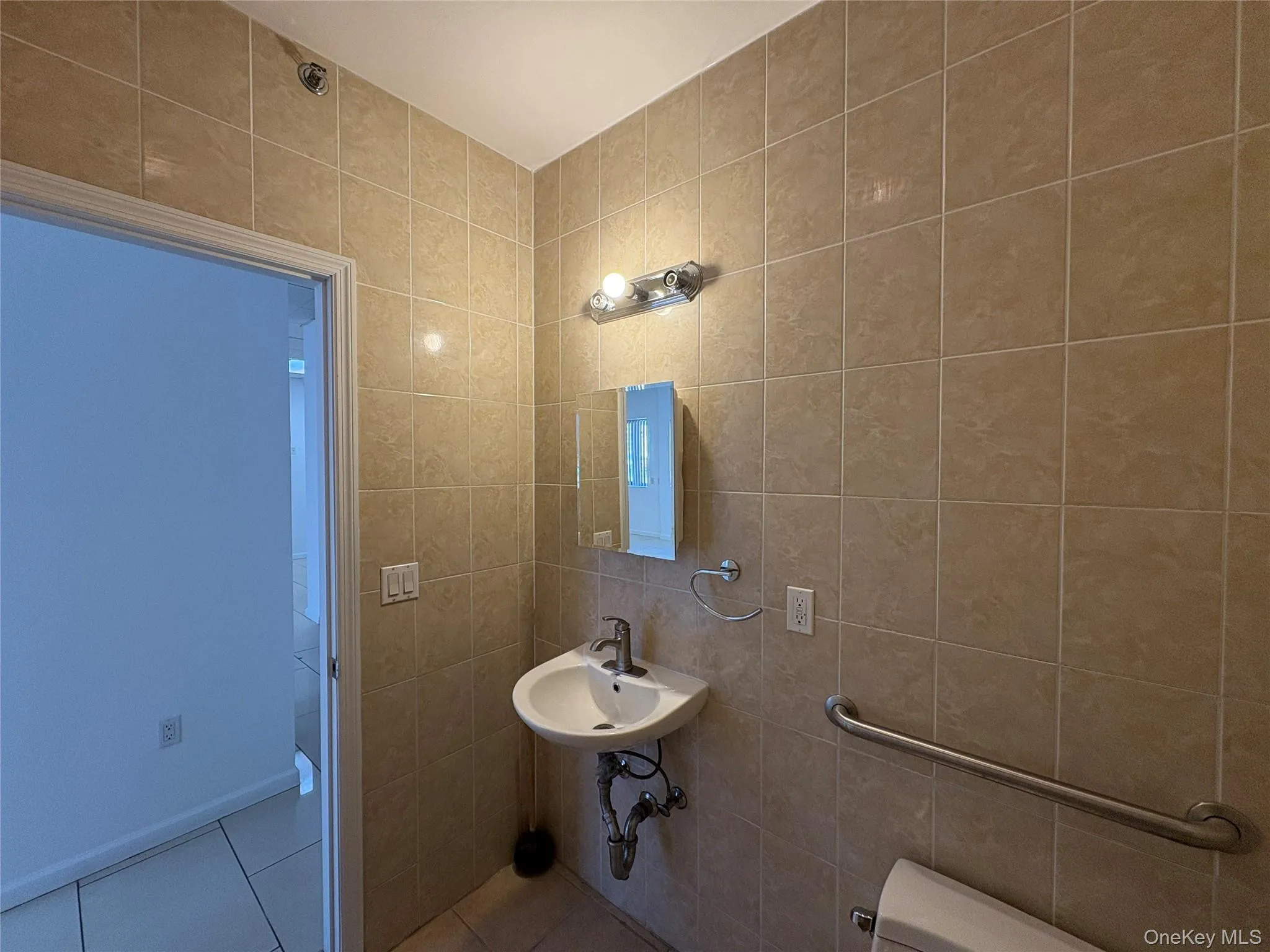 Bathroom featuring tile walls and tile patterned floors Bathroom featuring tile walls and tile patterned floors