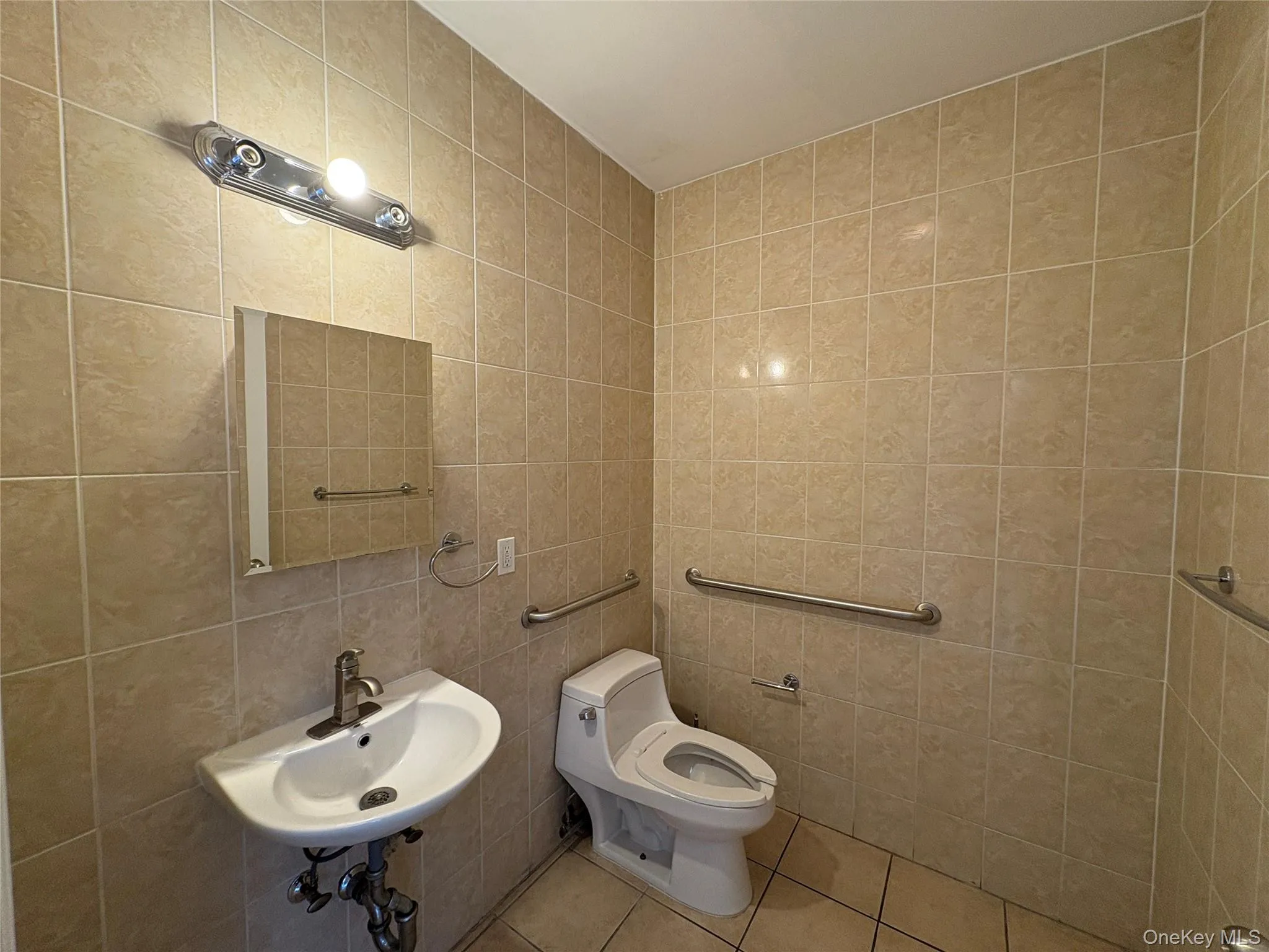 Half bathroom featuring tile walls and tile patterned flooring Half bathroom featuring tile walls and tile patterned flooring