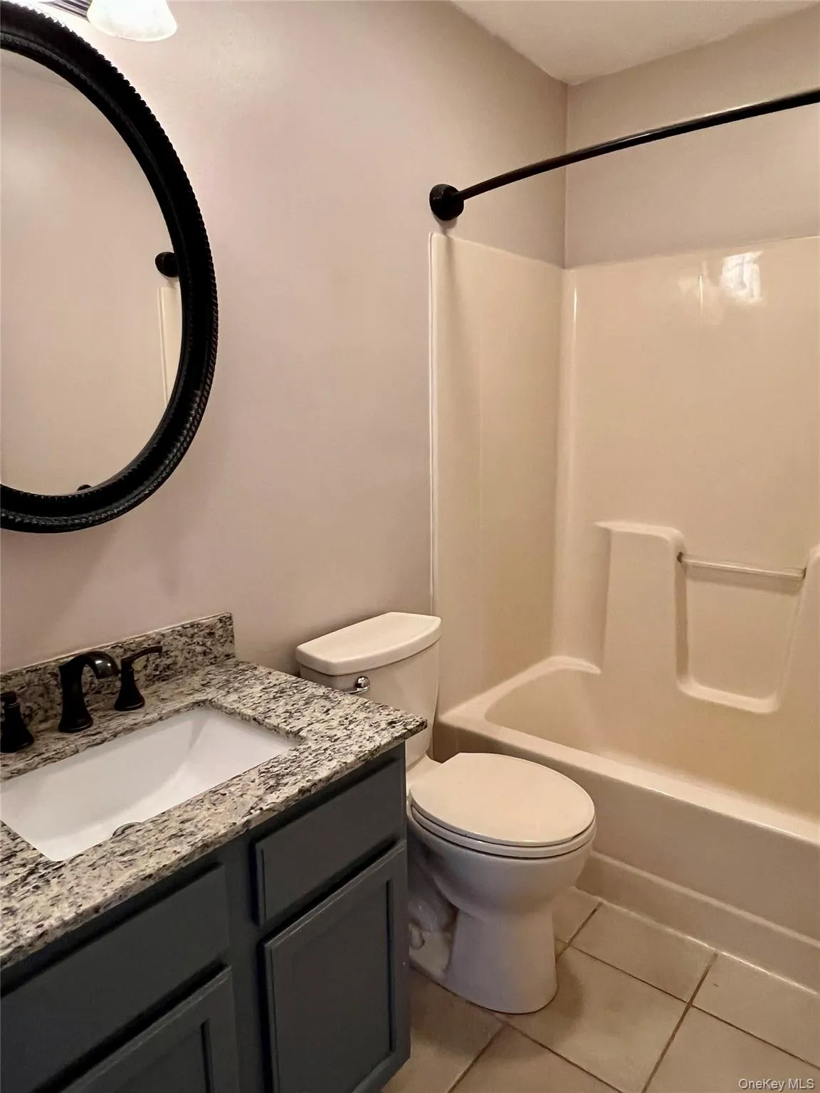 Full bathroom featuring light tile patterned flooring, shower combination, and vanity Full bathroom featuring light tile patterned flooring, shower combination, and vanity