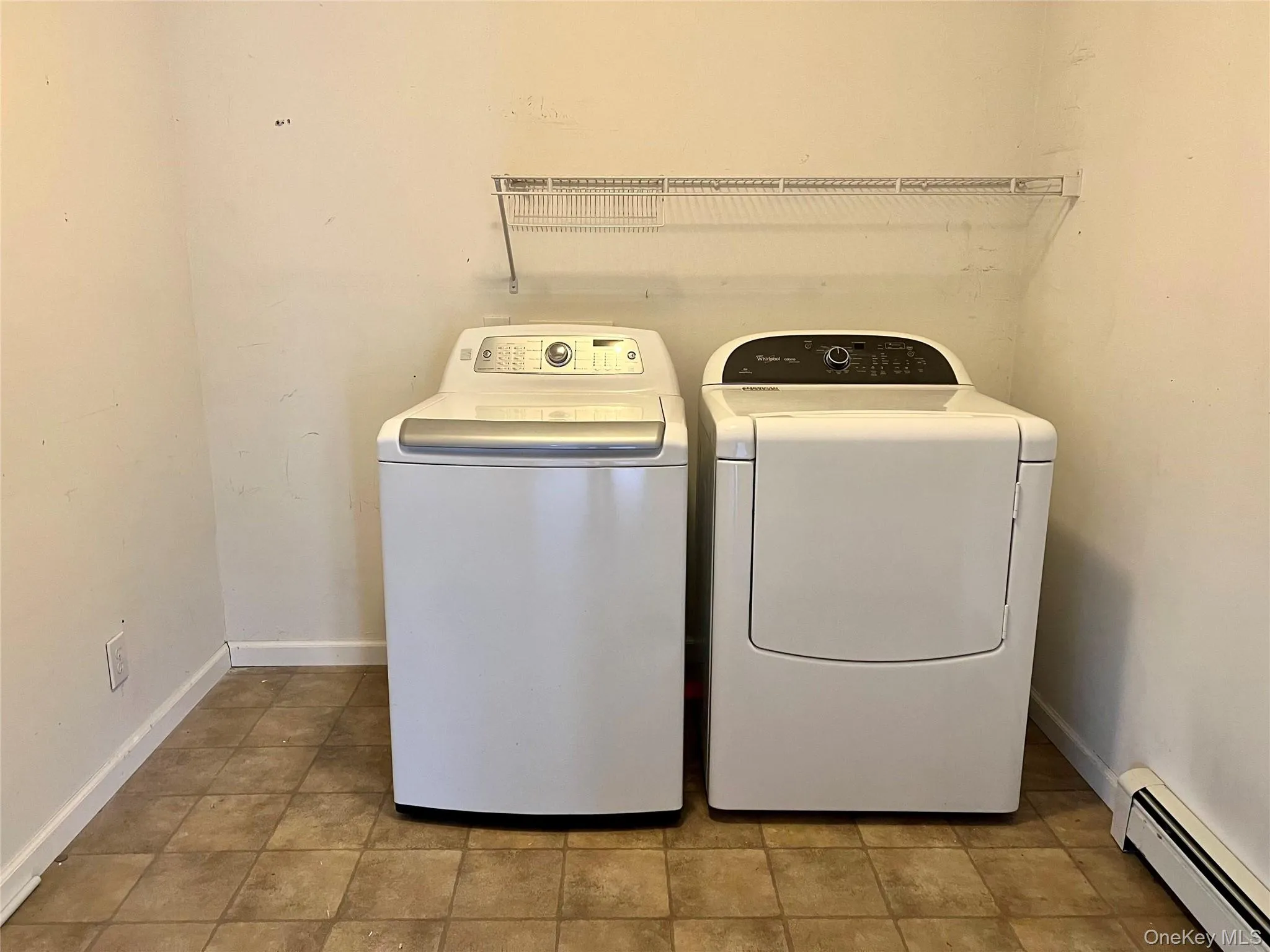 Washroom with baseboard heating and washing machine and clothes dryer Washroom with baseboard heating and washing machine and clothes dryer