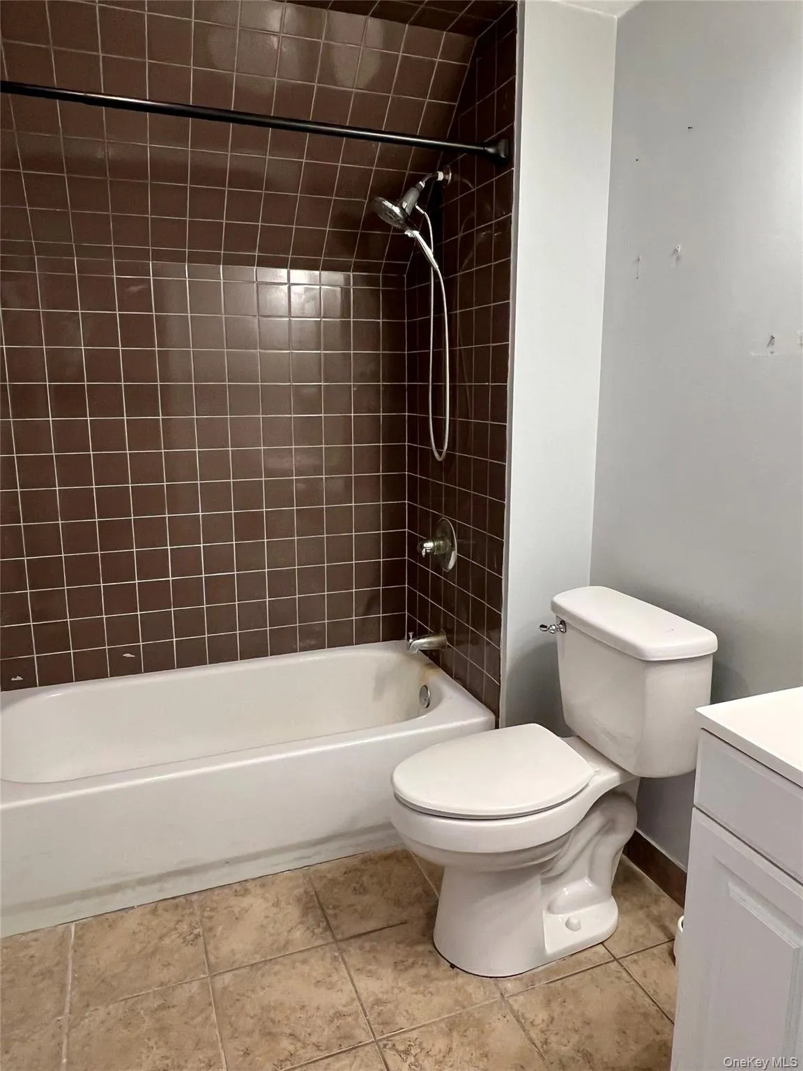 Bathroom with shower / bathtub combination, vanity, and light tile patterned floors Bathroom with shower / bathtub combination, vanity, and light tile patterned floors