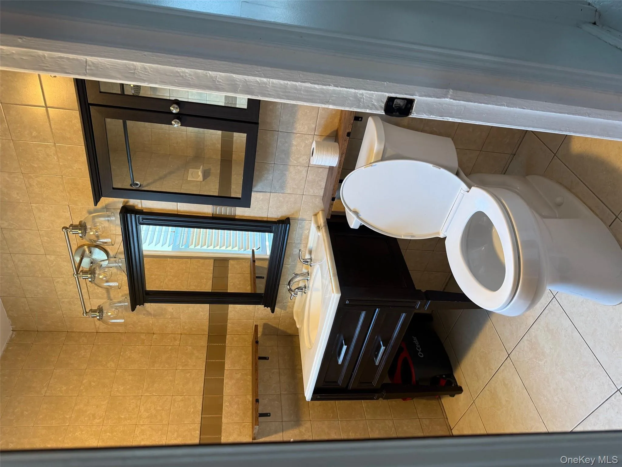 Half bath featuring tile walls, light tile patterned floors, and vanity Half bath featuring tile walls, light tile patterned floors, and vanity