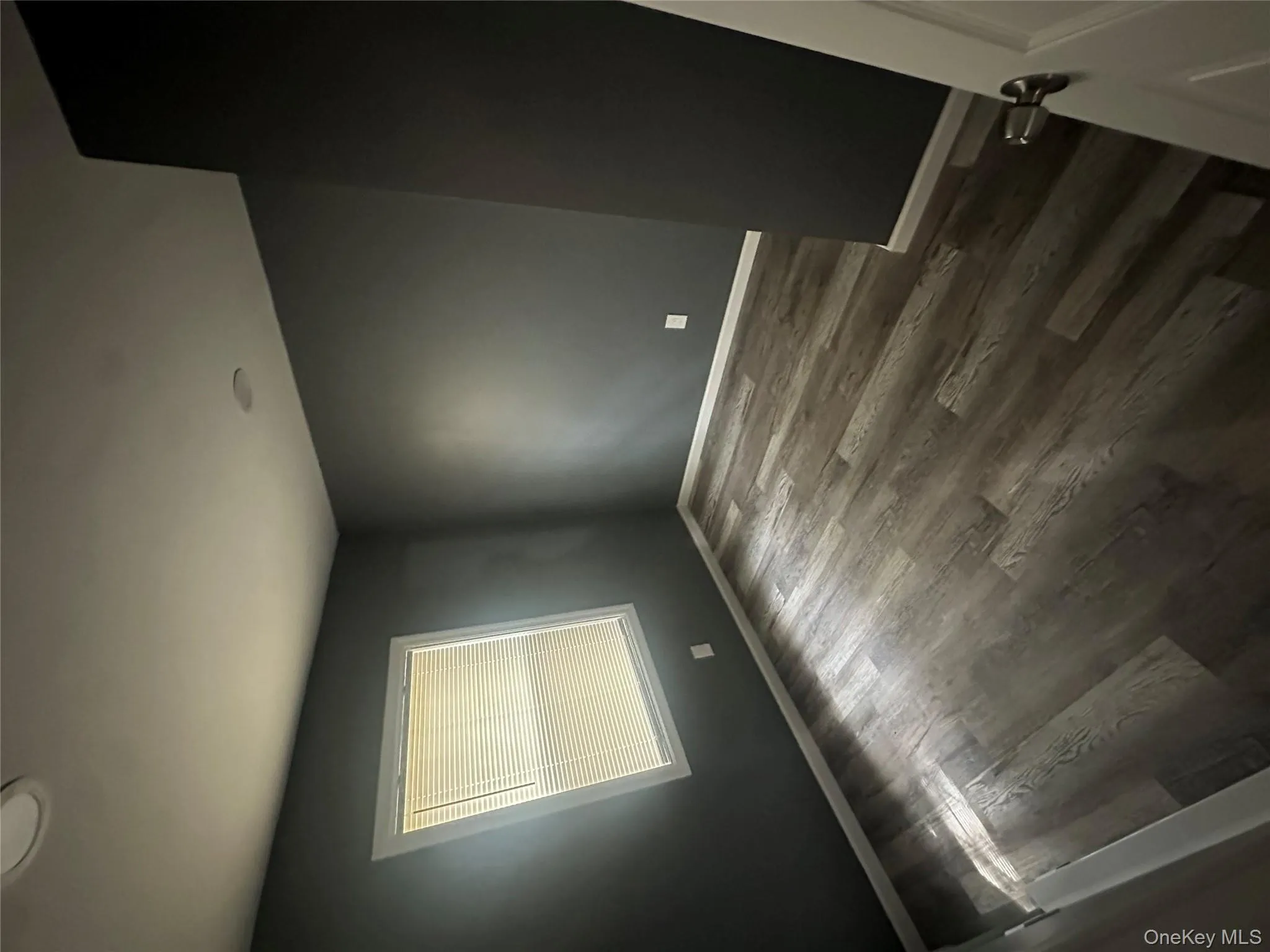 Spare room with dark wood-style flooring and baseboards Spare room with dark wood-style flooring and baseboards