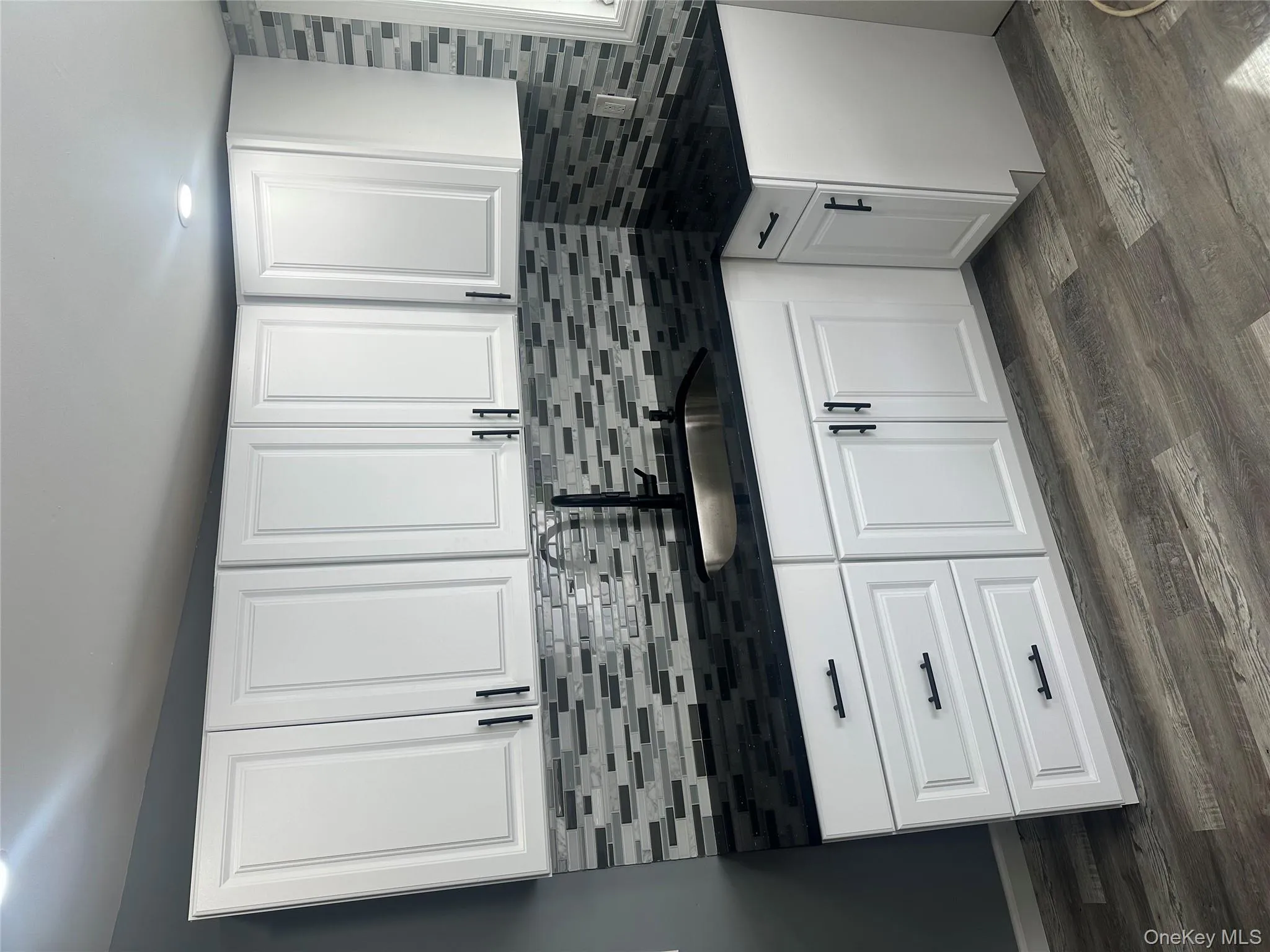 Kitchen featuring white cabinetry, dark wood finished floors, and recessed lighting Kitchen featuring white cabinetry, dark wood finished floors, and recessed lighting