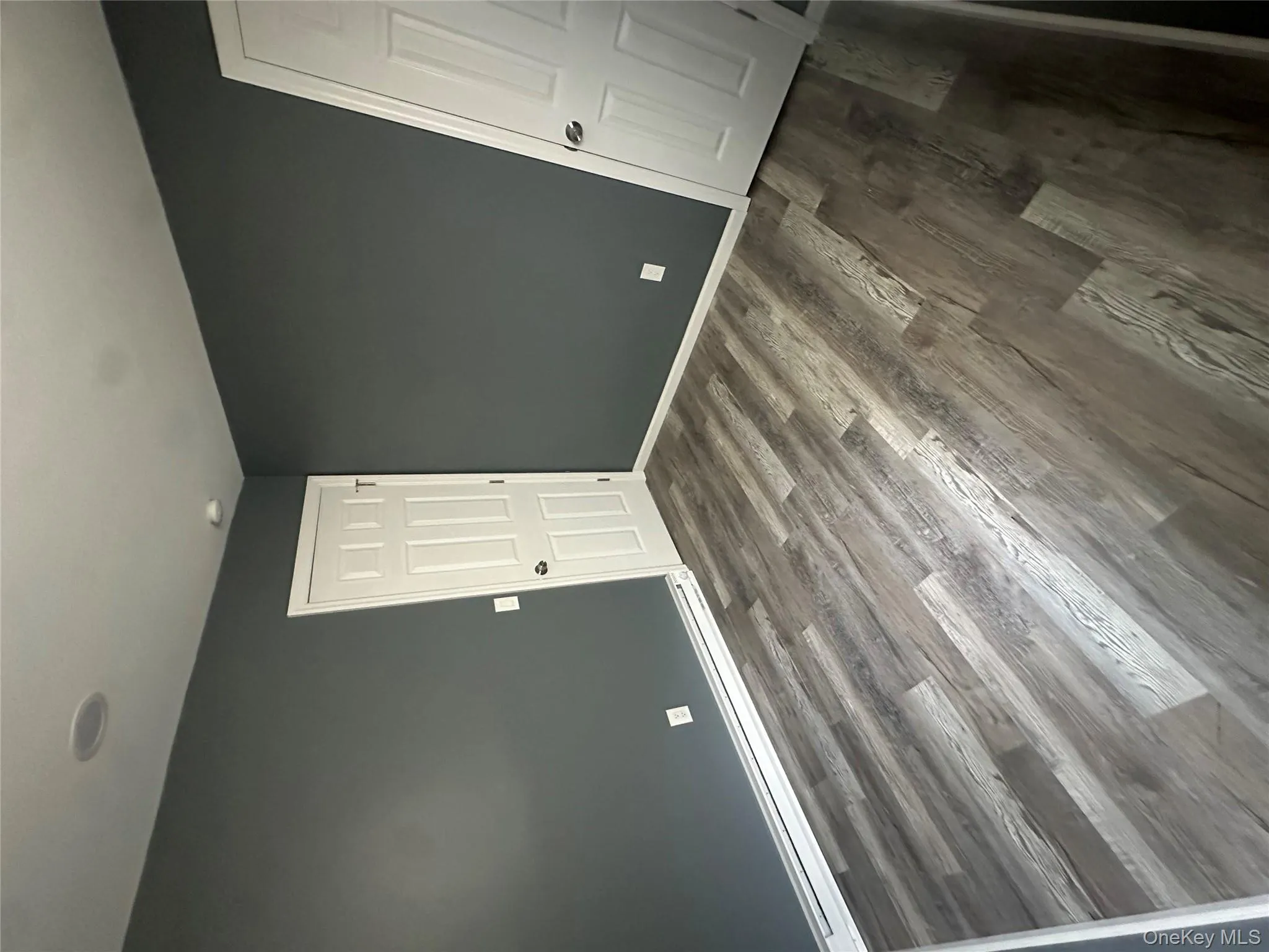 Unfurnished bedroom featuring a baseboard heating unit and dark wood-type flooring Unfurnished bedroom featuring a baseboard heating unit and dark wood-type flooring
