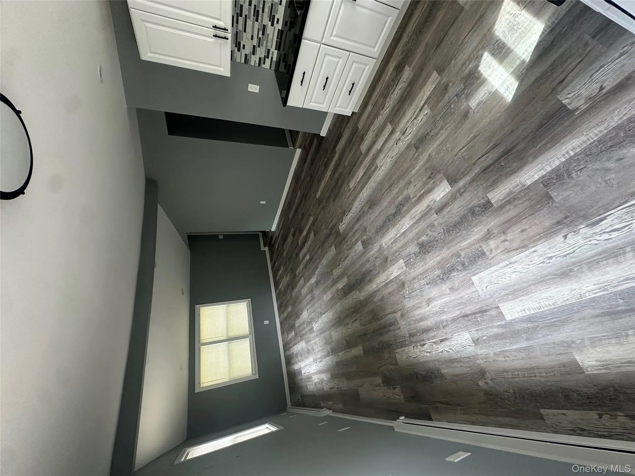 Unfurnished living room with beamed ceiling, baseboard heating, and dark wood finished floors Unfurnished living room with beamed ceiling, baseboard heating, and dark wood finished floors