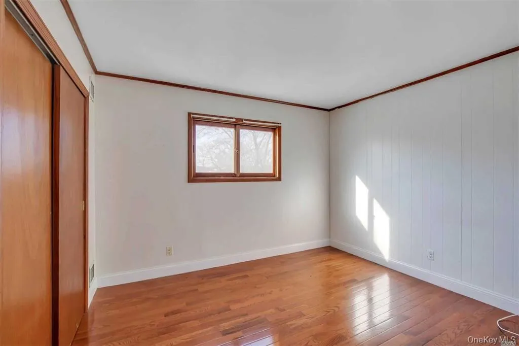 Unfurnished bedroom with light wood-style floors, crown molding, and a closet Unfurnished bedroom with light wood-style floors, crown molding, and a closet