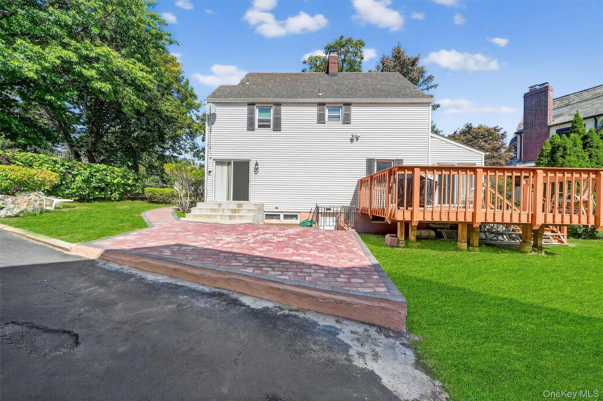 Back of property with a yard, a chimney, and a wooden deck Back of property with a yard, a chimney, and a wooden deck