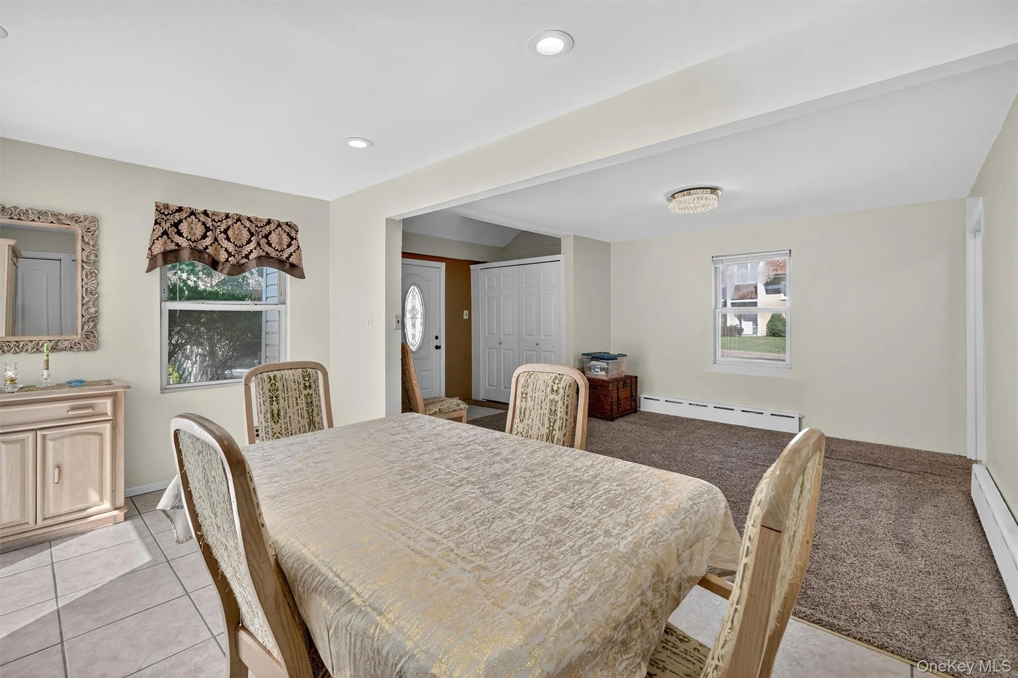 Dining space featuring baseboard heating, light tile patterned flooring, recessed lighting, and a baseboard radiator Dining space featuring baseboard heating, light tile patterned flooring, recessed lighting, and a baseboard radiator
