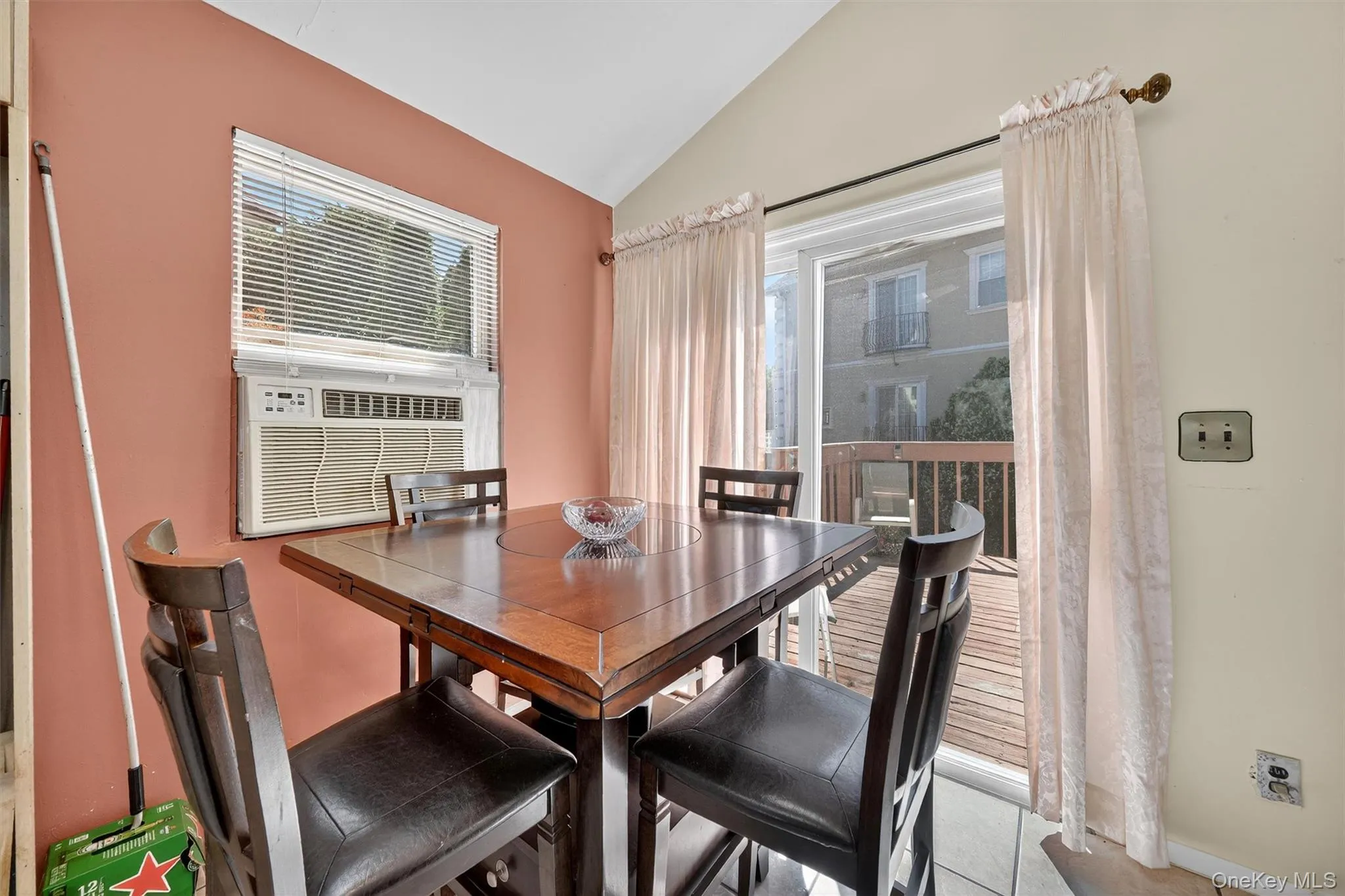 Dining space featuring lofted ceiling, light tile patterned flooring, and cooling unit Dining space featuring lofted ceiling, light tile patterned flooring, and cooling unit
