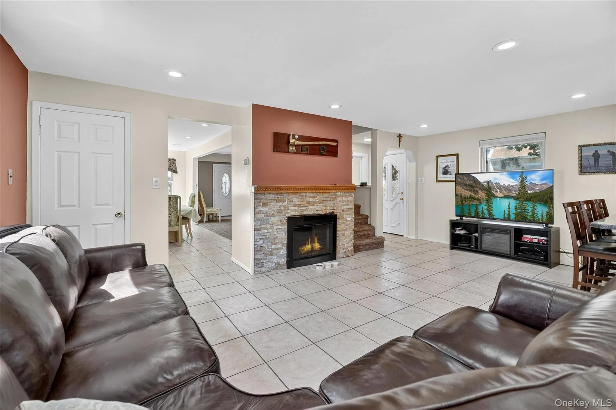 Living area featuring light tile patterned floors, recessed lighting, and a fireplace Living area featuring light tile patterned floors, recessed lighting, and a fireplace