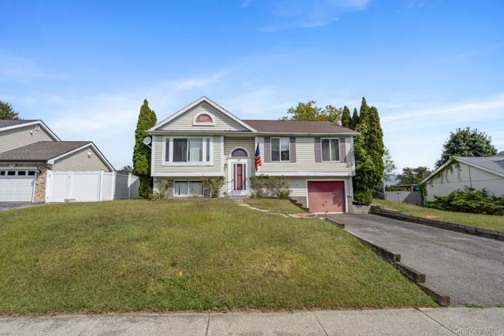 Raised ranch featuring driveway and an attached garage