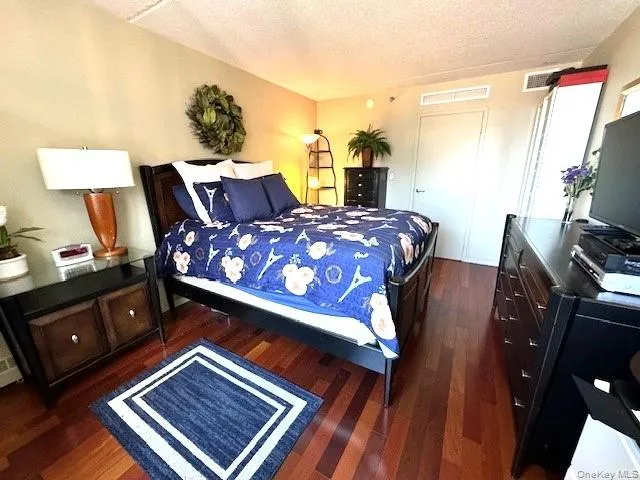 Bedroom featuring hardwood / wood-style floors and a textured ceiling Bedroom featuring hardwood / wood-style floors and a textured ceiling