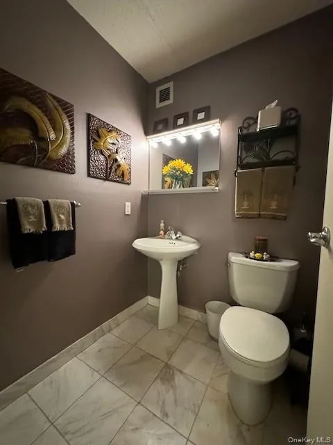Bathroom featuring tile patterned floors and toilet Bathroom featuring tile patterned floors and toilet
