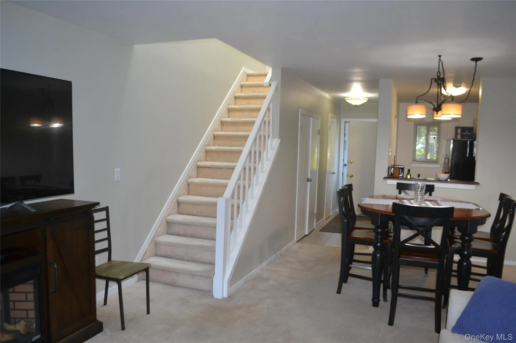 Dining space featuring stairway and light carpet Dining space featuring stairway and light carpet