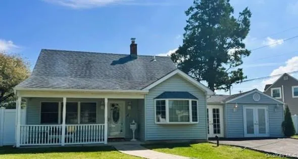 Rear view of property with a chimney, a porch, french doors, and a shingled roof Rear view of property with a chimney, a porch, french doors, and a shingled roof
