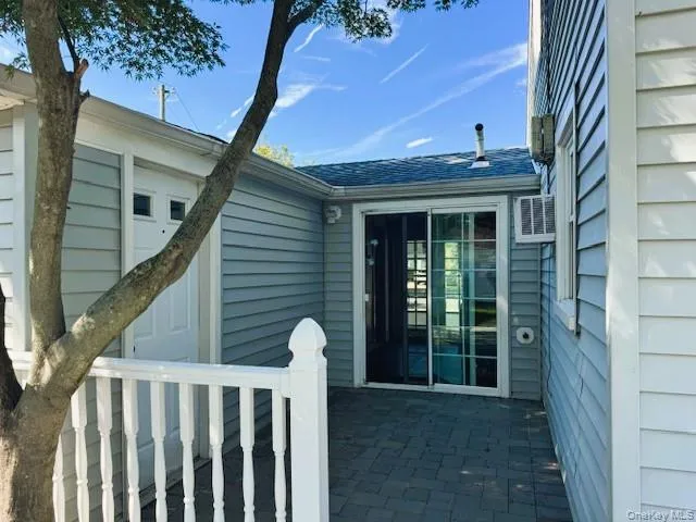 Property entrance featuring a patio and a shingled roof Property entrance featuring a patio and a shingled roof