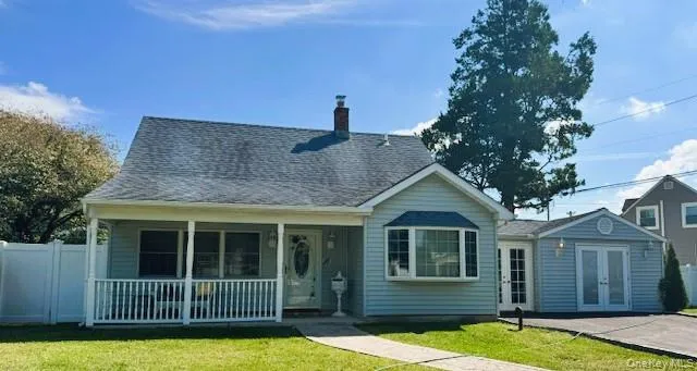 View of front facade with a chimney, a porch, roof with shingles, and french doors View of front facade with a chimney, a porch, roof with shingles, and french doors