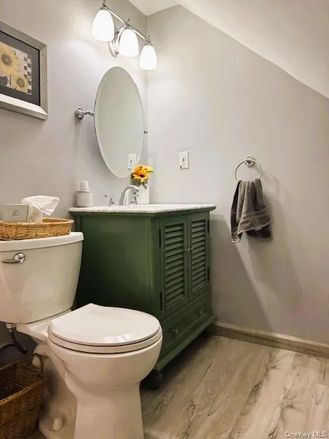 Half bath with light wood-style floors and vanity Half bath with light wood-style floors and vanity