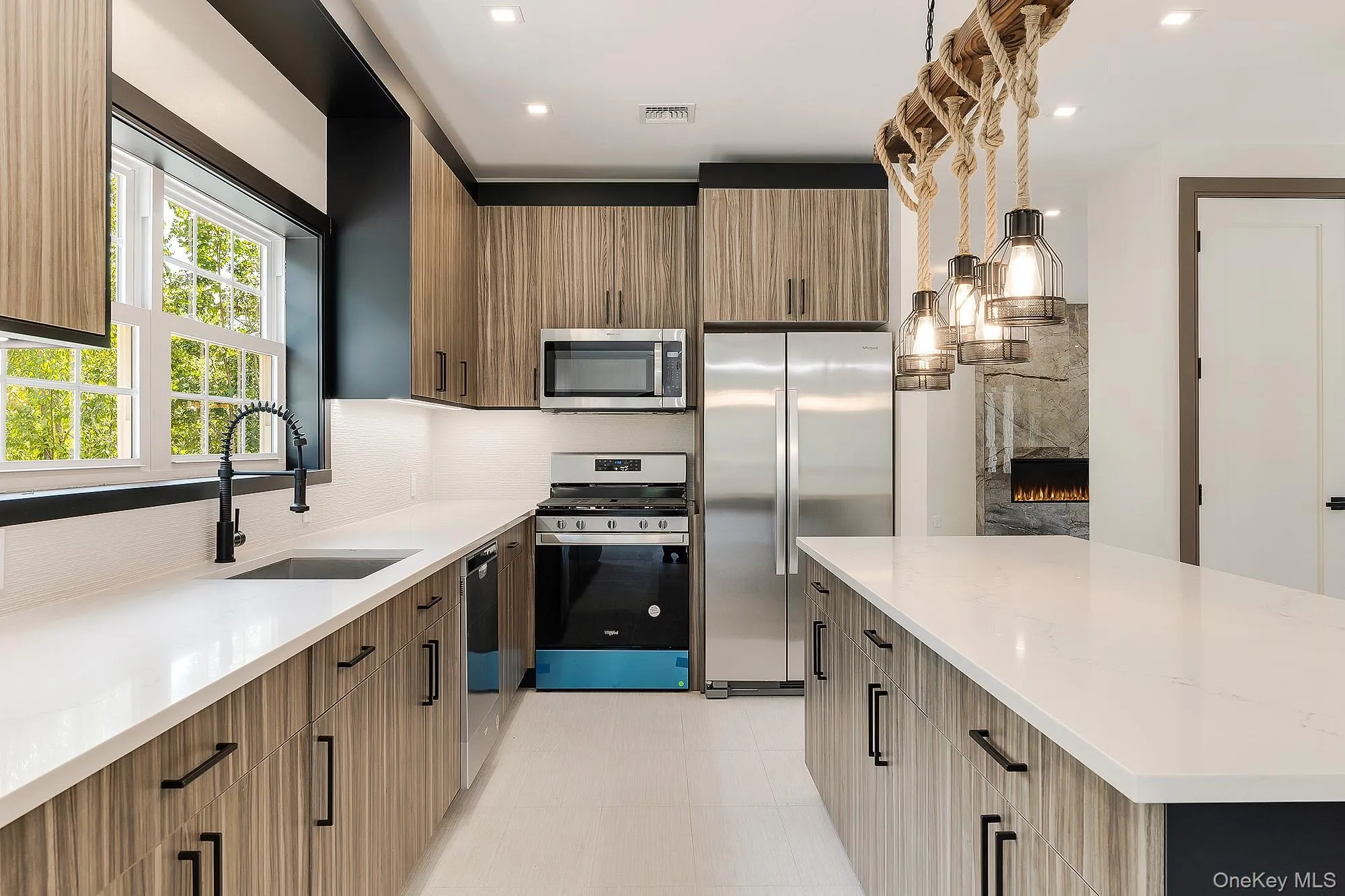 Kitchen featuring modern cabinets, visible vents, a sink, stainless steel appliances, and decorative backsplash Kitchen featuring modern cabinets, visible vents, a sink, stainless steel appliances, and decorative backsplash