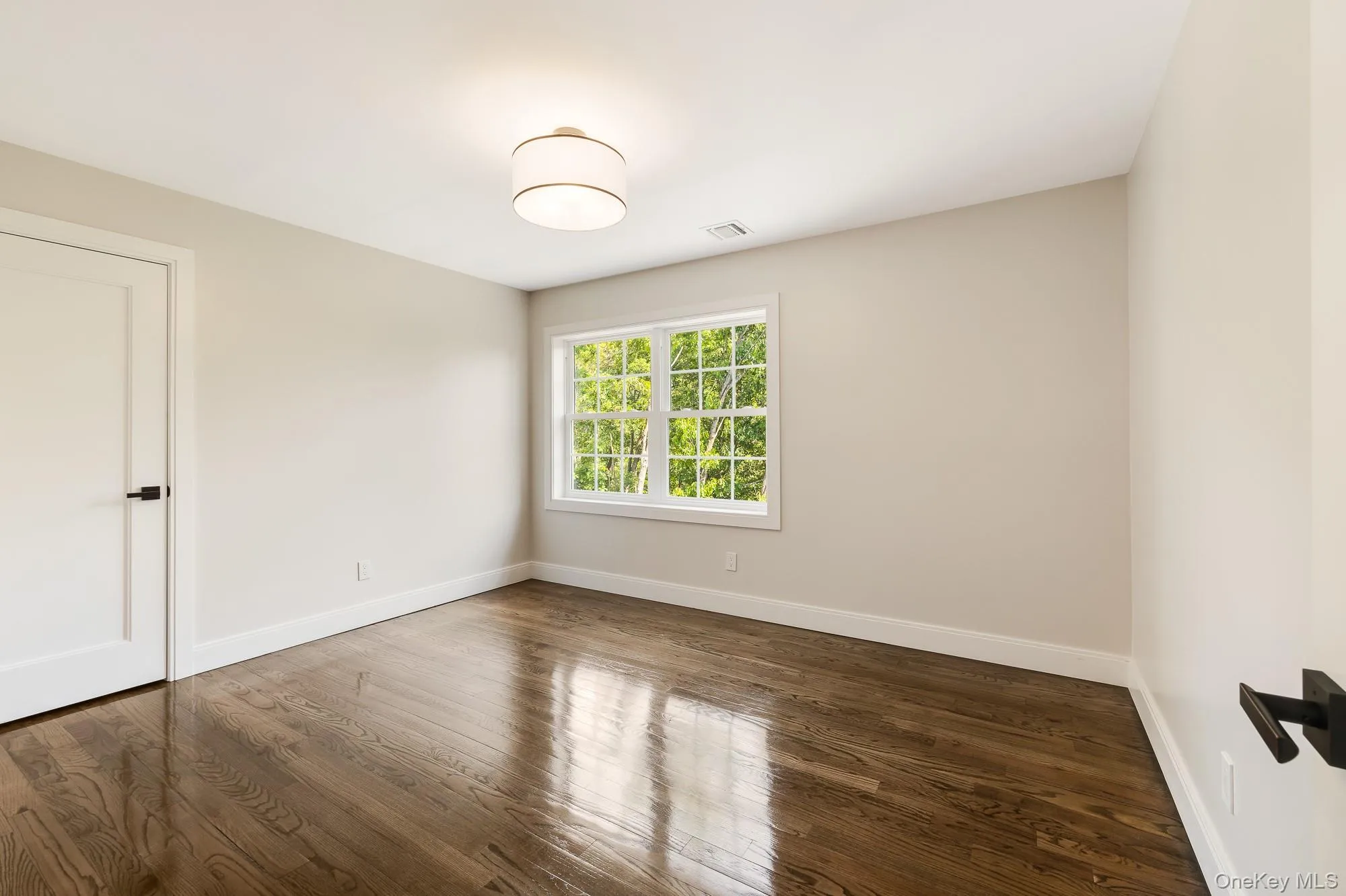 Spare room with visible vents, and wood finished floors Spare room with visible vents, and wood finished floors