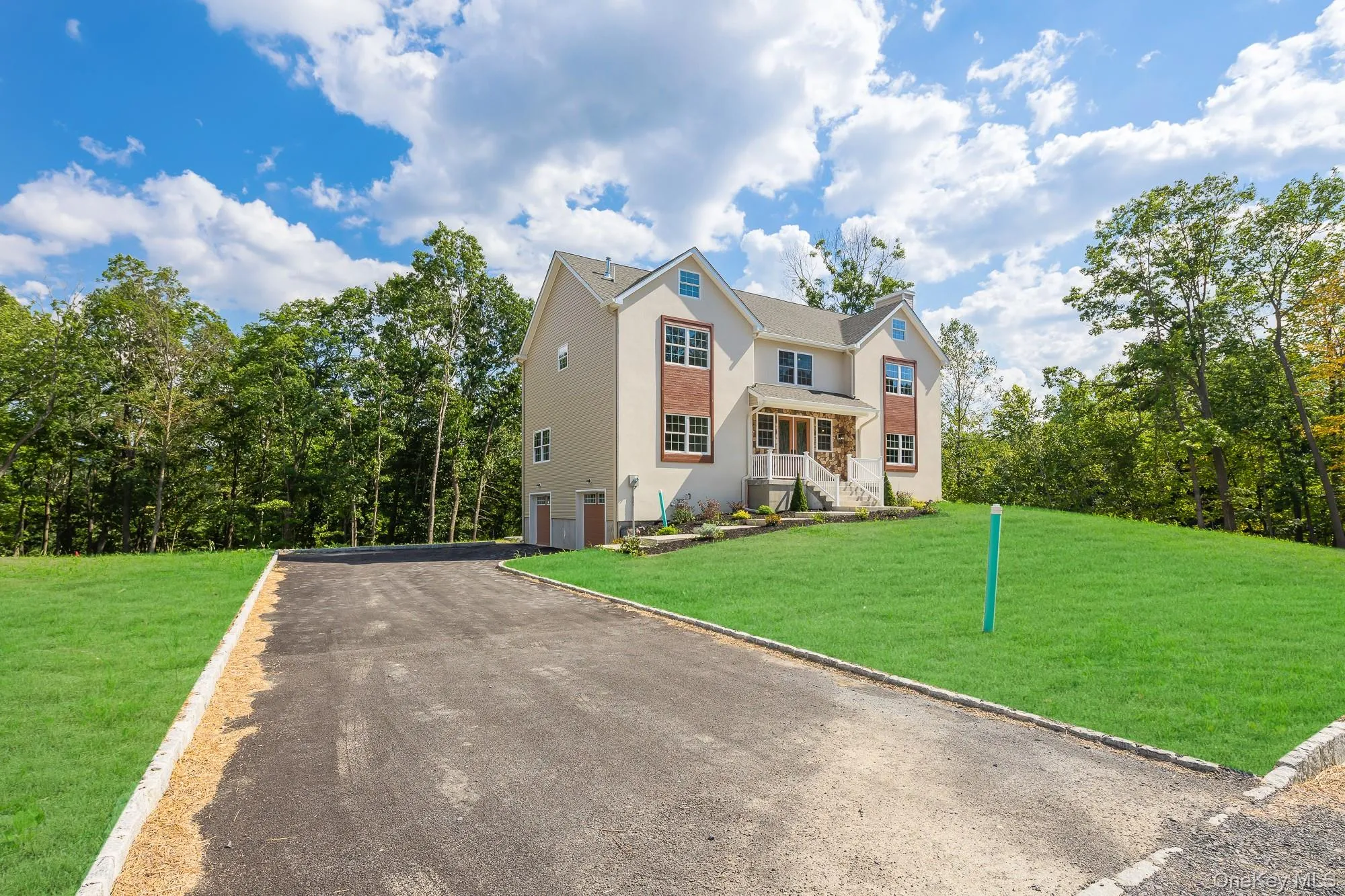 View of front of house with a garage, a front yard, driveway, and stucco siding View of front of house with a garage, a front yard, driveway, and stucco siding