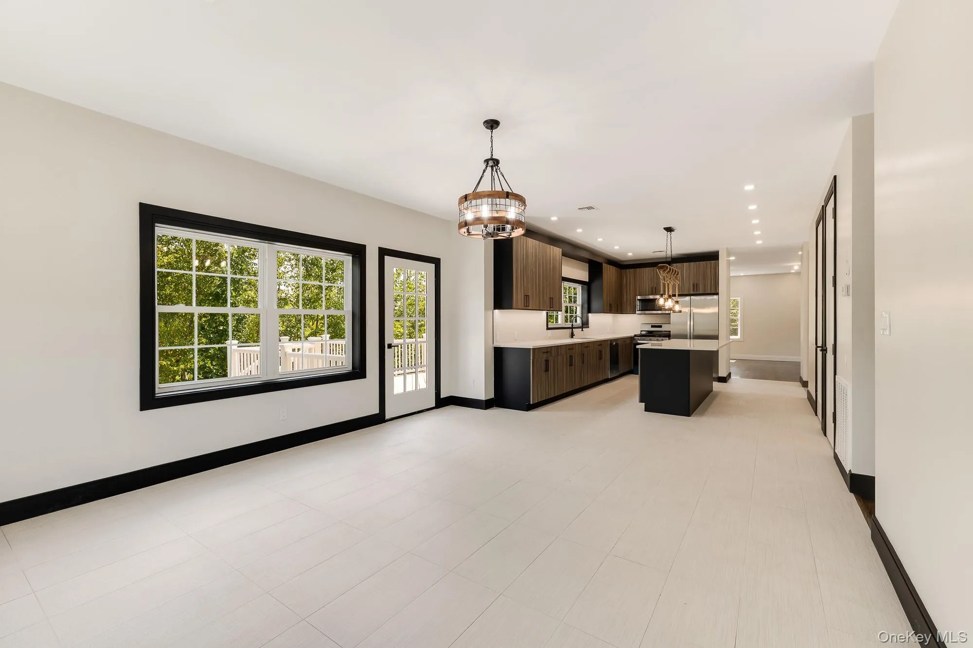 Kitchen with light countertops, appliances with stainless steel finishes, and an inviting chandelier. Kitchen with light countertops, appliances with stainless steel finishes, and an inviting chandelier.