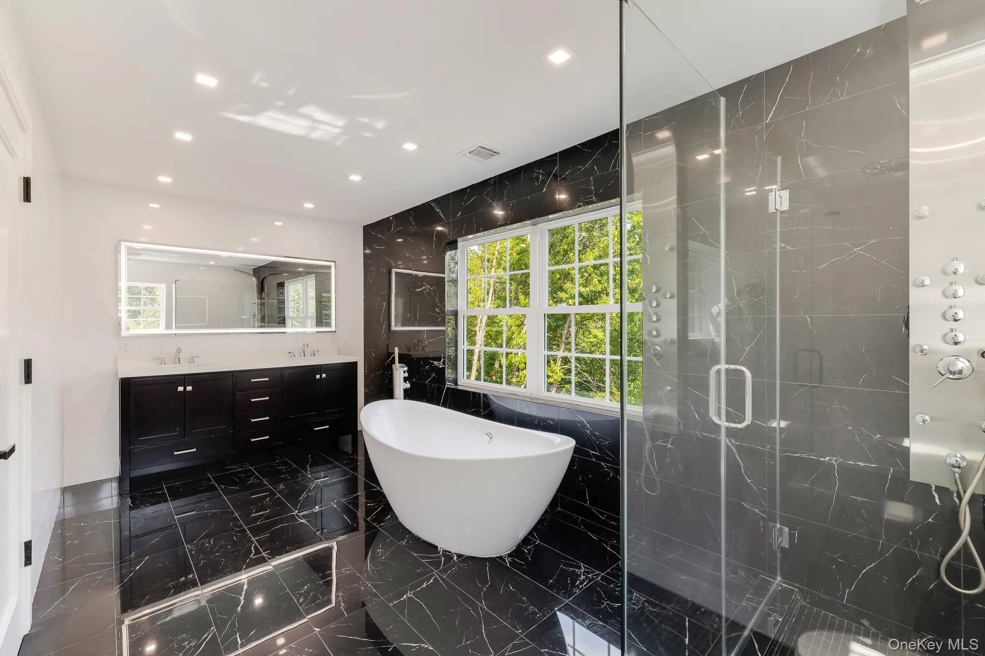 Bathroom featuring a freestanding tub, double vanity, a shower stall, visible vents, and marble finish floor Bathroom featuring a freestanding tub, double vanity, a shower stall, visible vents, and marble finish floor