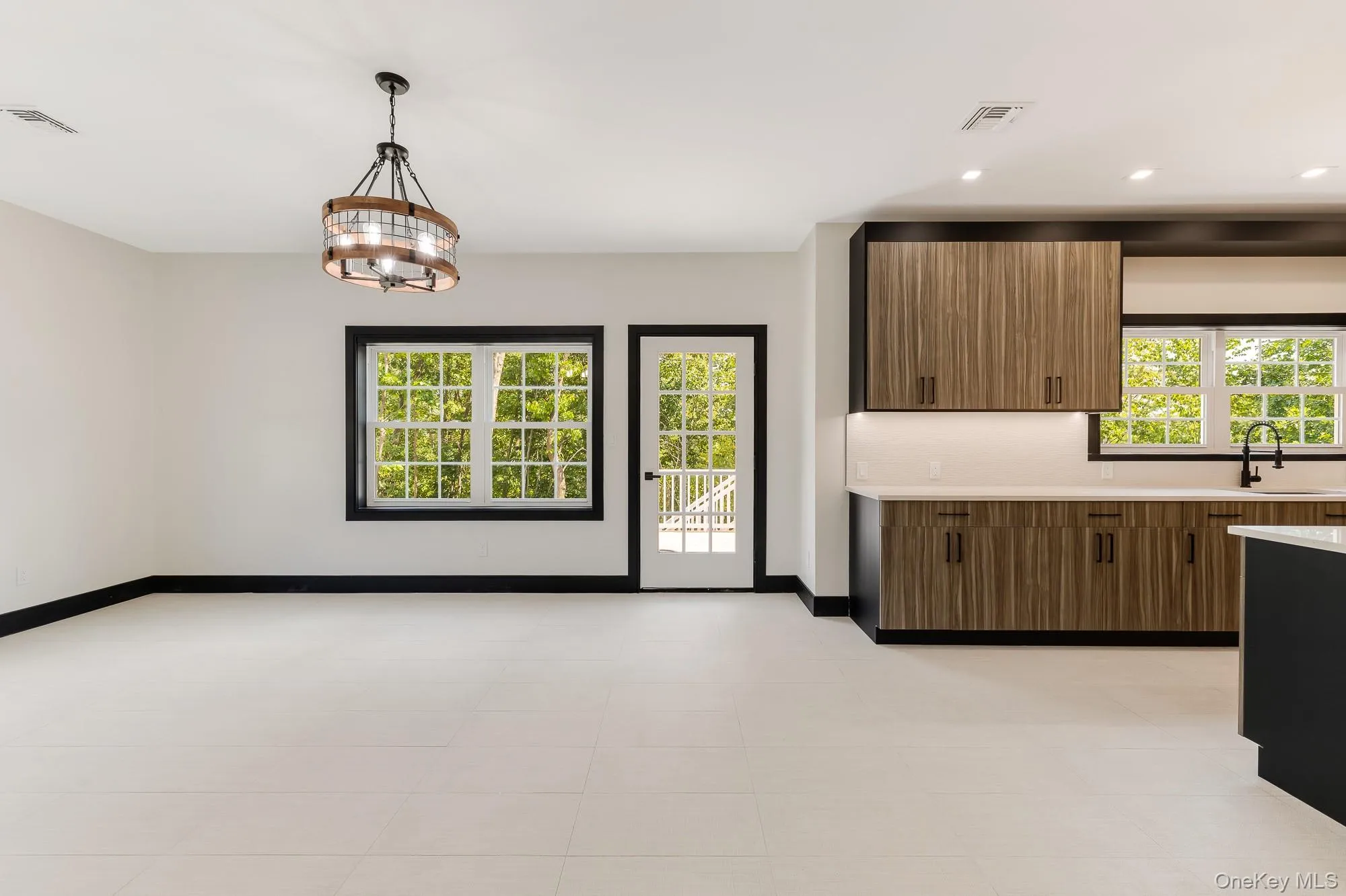 Kitchen featuring recessed lighting, light countertops, visible vents, and a sink Kitchen featuring recessed lighting, light countertops, visible vents, and a sink