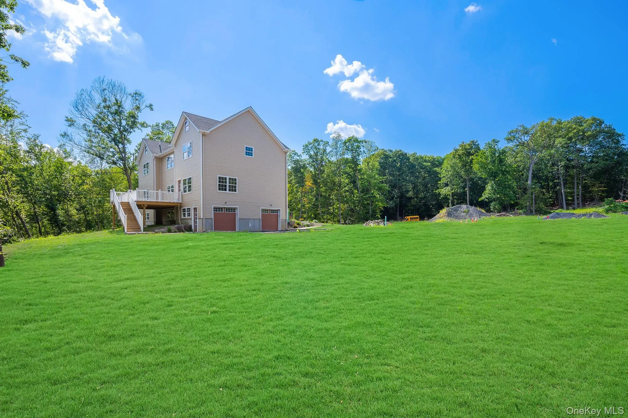 View of yard with stairway, a deck, and an attached garage View of yard with stairway, a deck, and an attached garage