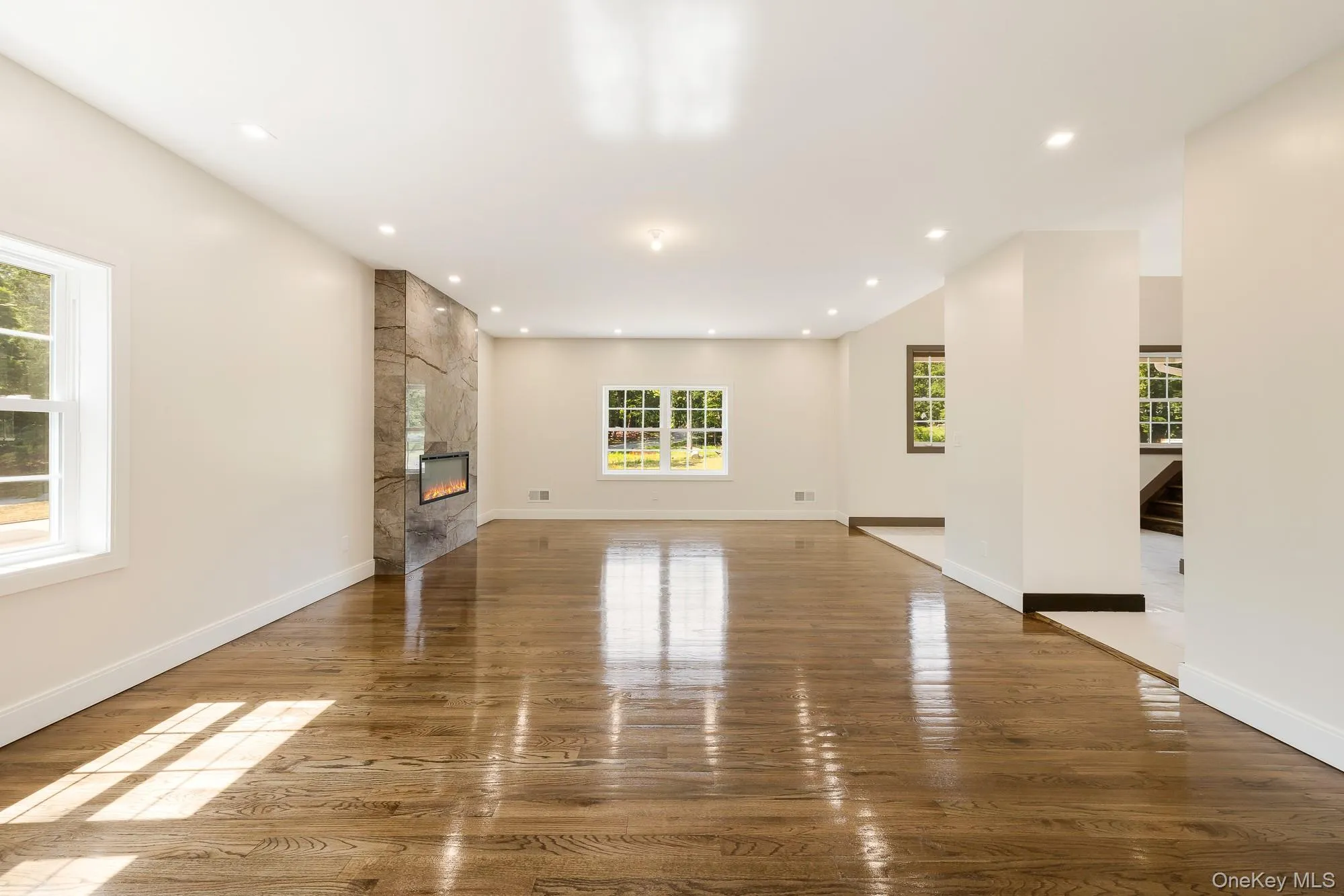 Unfurnished living room featuring recessed lighting, a fireplace, and wood finished floors Unfurnished living room featuring recessed lighting, a fireplace, and wood finished floors