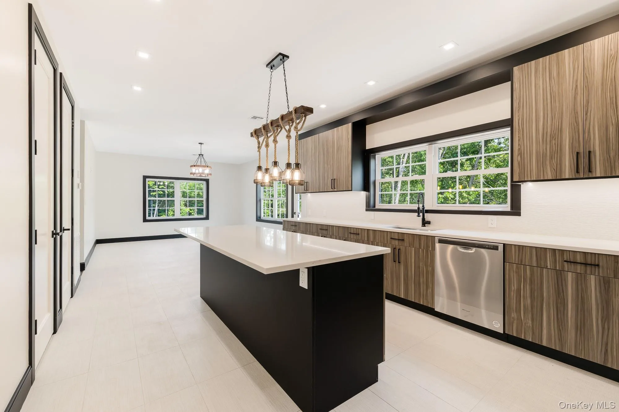 Kitchen with light countertops, dishwasher, a sink, and modern cabinets Kitchen with light countertops, dishwasher, a sink, and modern cabinets